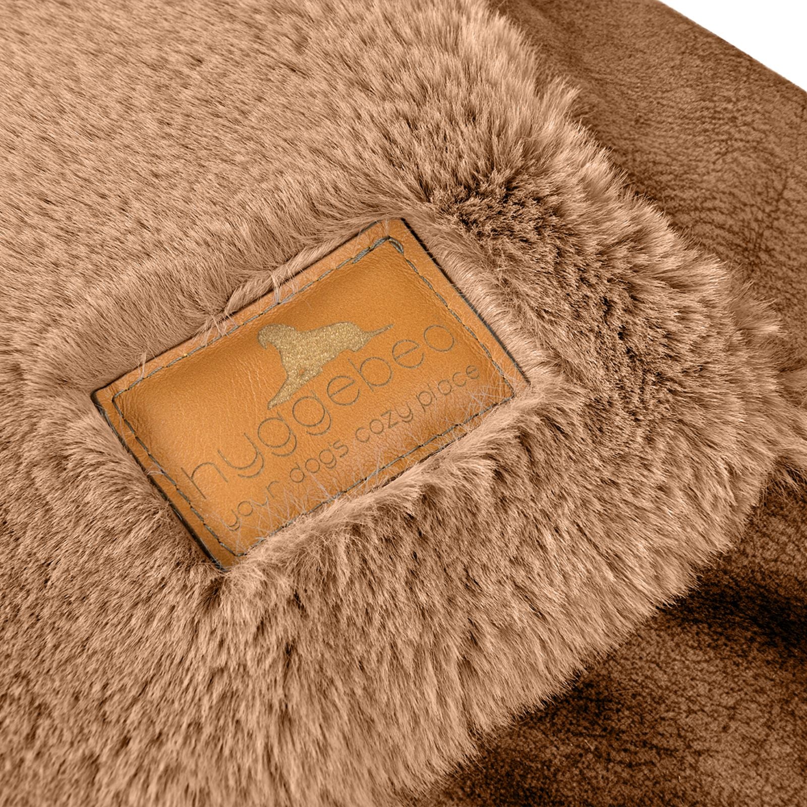 Nahaufnahme des edlen braunen Leder-Labels mit eingeprägtem Hyggebed Logo auf dem braunen Maroon Plüsch-Stoff