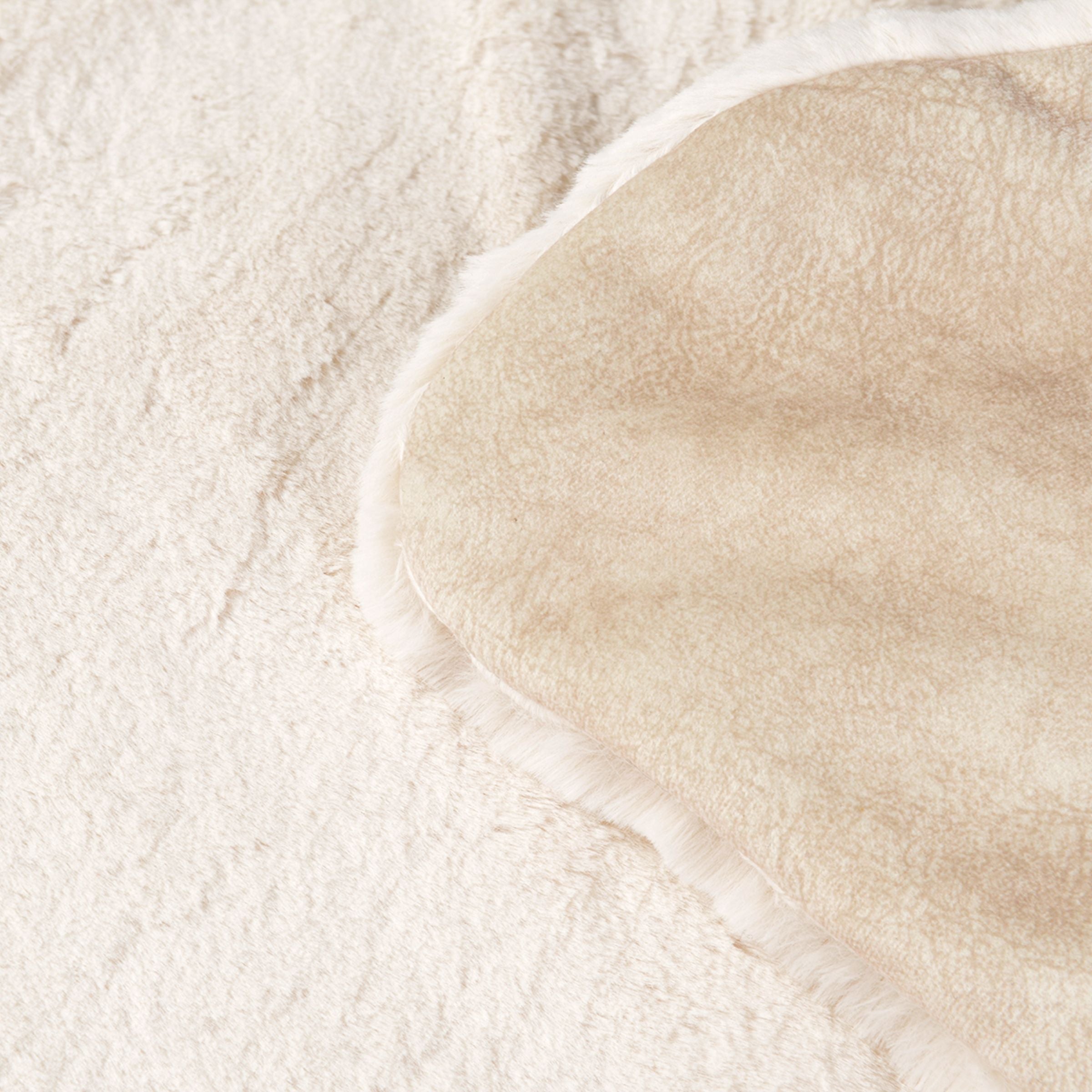 Detailaufnahme der zwei Seiten der cremeweißen Hundedecke Hyggelamb mit flauschigem Lammfell-Imitat und beiger Sommerseite
