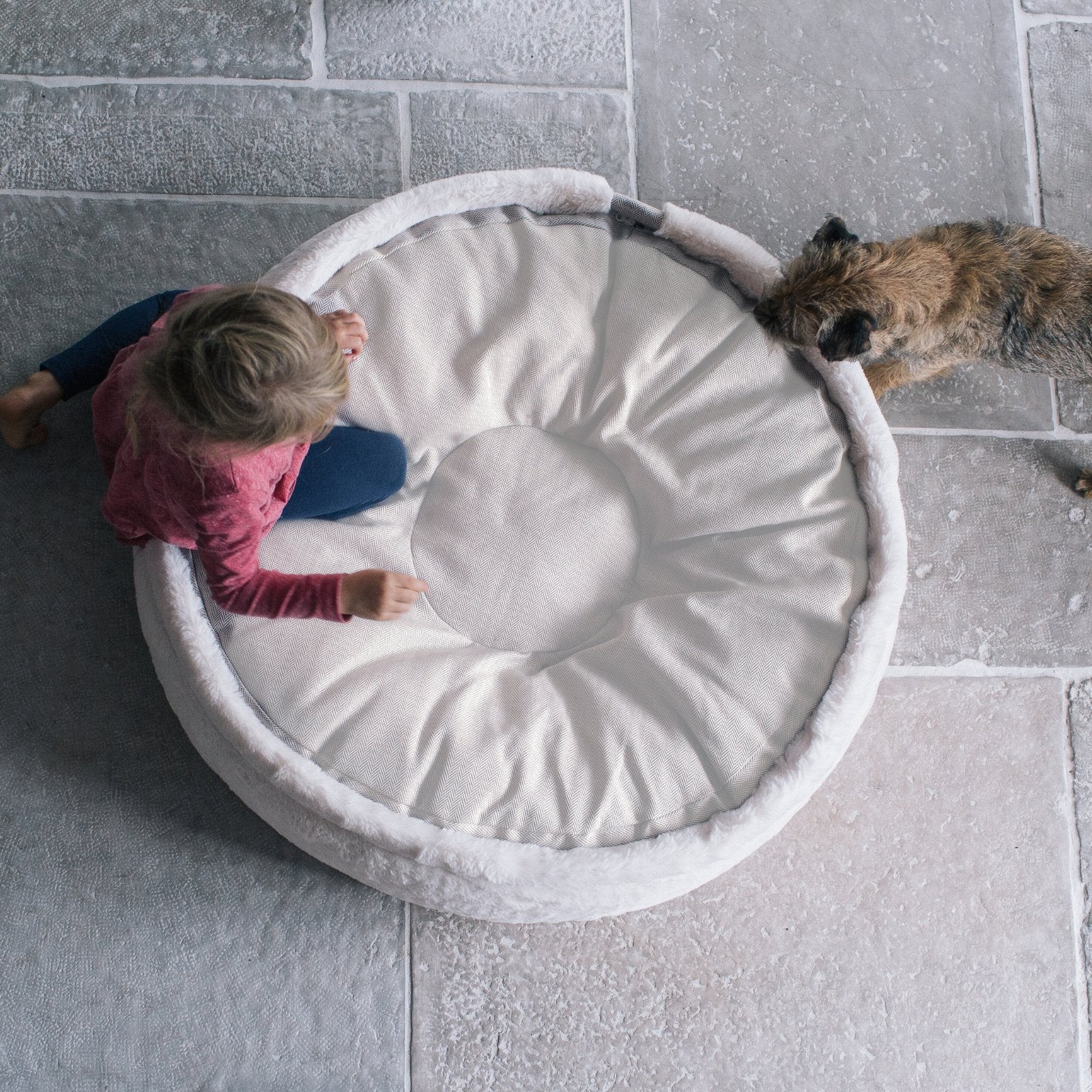 Alt-Text: Kind entspannt mit Hund auf dem orthopädischen Hyggebed mit Sommer- und Winterseite für perfekten Klimakomfort